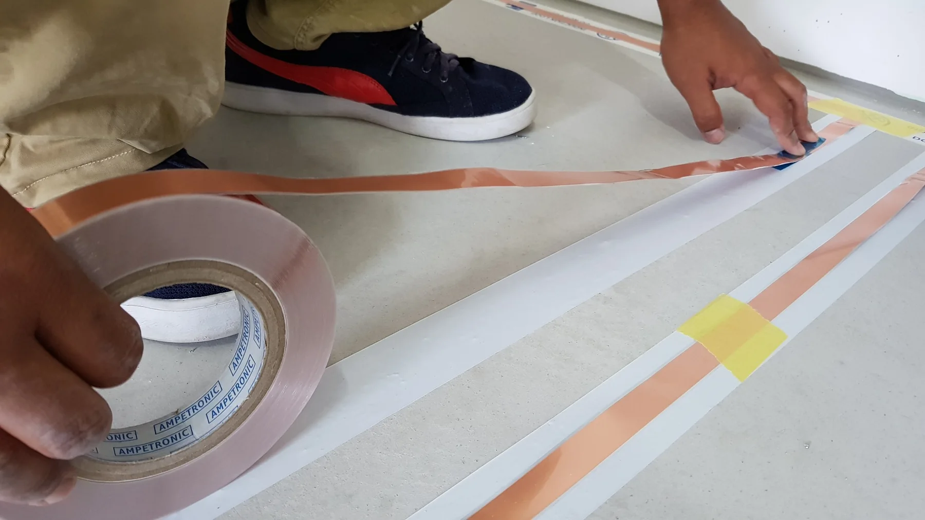 Close-up of Ampetronic flat copper tape used for an under-floor hearing loop in Malaysia
